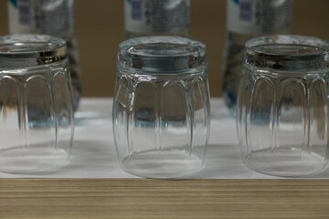 Three inverted empty glasses on a wooden surface.