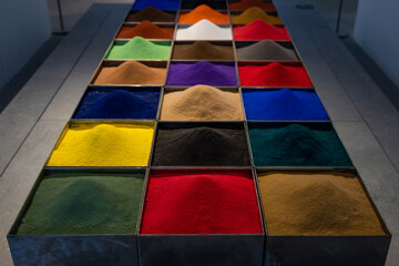 Close up of an array of boxes containing colorful powder
