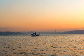 Beautiful misty sunrise over the Bosporus, with the European and Asian shores as a ferry crosses towards Karakoy and Galataport, Turkey