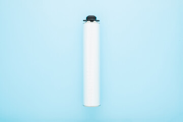 Light gray metallic container for professional foam spray gun on light blue table background....