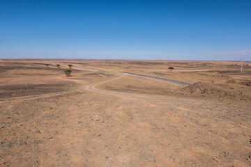 Fototapeta na wymiar A winding road through the vast Sahara desert of Morocco