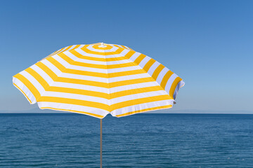 .Yellow umbrella on the top of mountain, cliff with blue sea, ocean, sky view. .