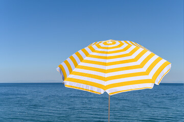 .Yellow umbrella on the top of mountain, cliff with blue sea, ocean, sky view. .
