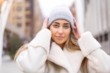 Winter portrait of a caucasian woman in a wool hat in the city, lifestyle