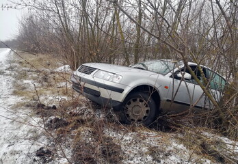 Car in a ditch. Slippery road. Winter accident. Car accident in winter. An abandoned car in a ditch...