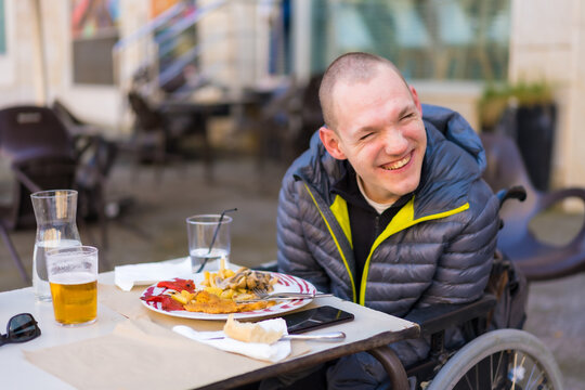 Portrait Of A Disabled Person In A Wheelchair In A Restaurant Smiling And Having Fun