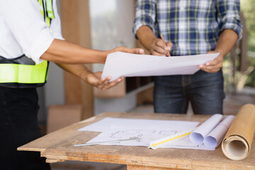 Working as a team architect and designer working on blueprint project of new apartments. Photo concept of work on technical drawings.