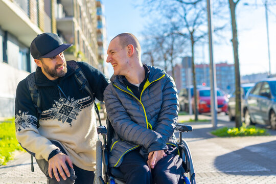 A disabled person in a wheelchair with a friend smiling, handicapped normality