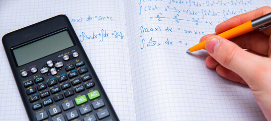 Close-up on a student solving math problems. Solving integrals. Study for the exam