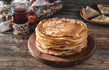 Pancakes for Maslenitsa. A stack of Russian thin pancakes. Traditional Russian festive food. Country style. Selective focus.