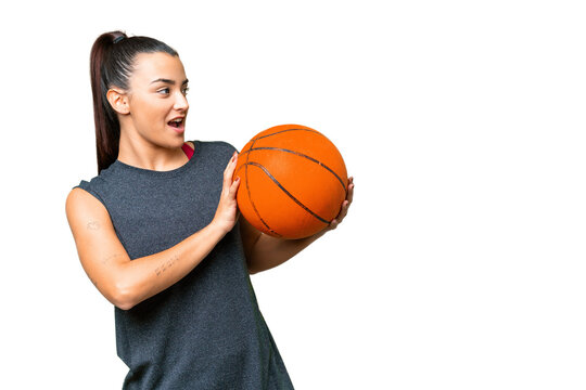 Young beauty woman over isolated chroma key background playing basketball