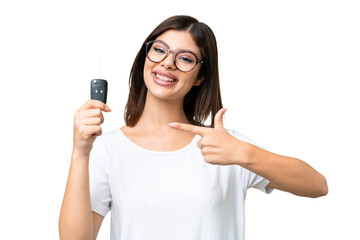 Young Russian woman holding car keys over isolated chroma key background and pointing it