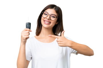 Young Russian woman holding car keys over isolated chroma key background and pointing it