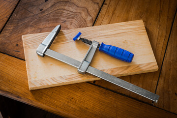 Restoration of an antique French wooden furniture using wood clamps to attach different parts of it