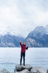Fototapeta na wymiar A boy takes a selfie with the snowy mountains behind him