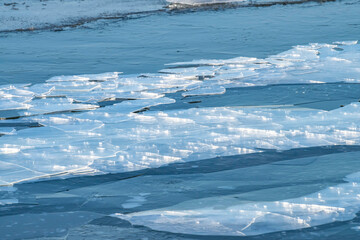 Sparkling blue ice floes in the frozen sea. Chunks of drifting ice near the coast of IJsselmeer in Almere. Icy texture background. © O de R