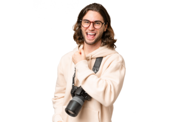 Young photographer man over isolated background celebrating a victory