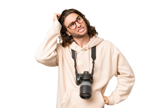 Young photographer man over isolated background having doubts and with confuse face expression