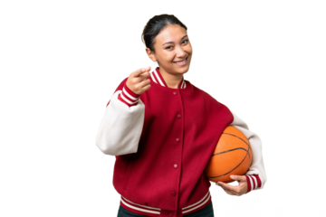 Young Uruguayan woman playing basketball over isolated wall  over isolated chroma key background pointing front with happy expression
