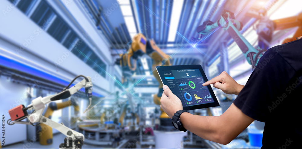 Wall mural Smart industry control concept.Engineer Hands holding tablet on blurred robot arm automation machine as background