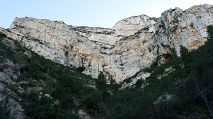 White mountain, sheer cliffs, stones, mountain vegetation, pine trees, beautiful unique landscape, Mount Montgo in Spain Alicante