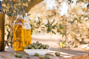 green olives and oil on table in olive grove