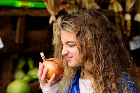 Girl smelling onion, Benton, Pennsylvania, USA