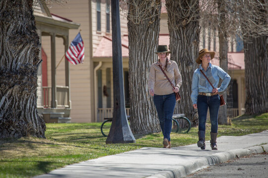 Two young women stroll down Officer's Row in Mammoth Hot Springs, Yellowstone.