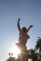 Beautiful young woman raising arms under blue sky, concept of freedom, hapiness and joy