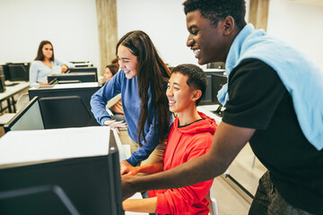 Young multiracial students using computers inside technology class at school room - Focus on asian guy face