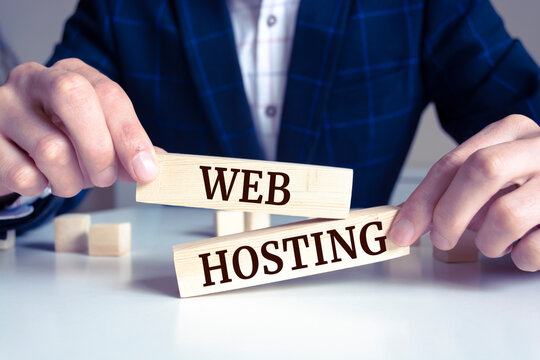 Closeup on businessman holding a wooden block with "WEB HOSTING"