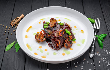 Meat medallions, glazed in spicy red gravy with fried mushrooms, menu photo