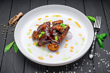 Meat medallions, glazed in spicy red gravy with fried mushrooms, menu photo