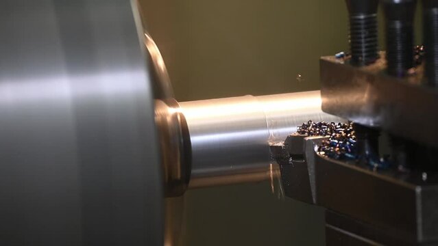Close up scene the lathe machine finish cut the metal shaft parts by insert tools.