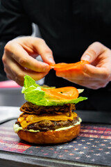 chef hand preparing a gourmet burger on restaurant kitchen step by step