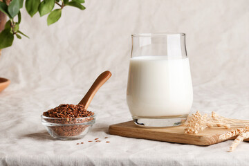 flax seed milk in glass on textile background with plant. copy space. Raw diet meal. Healthy...