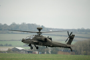 close-up of a British army AH-64E Boeing Apache Attack helicopter (ZM722 ArmyAir606) in a low hover on a military exercise, Wilts UK