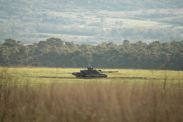 Fototapeta na wymiar a British army FV4034 Challenger 2 ii main battle tank on a traversing a field on a military combat exercise, Wiltshire UK