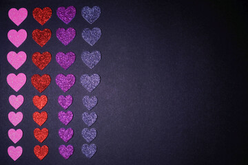 on a dark background, hearts are laid out in columns