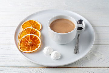 Coffee with cream, fluffy protein cake and dried oranges