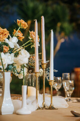 Beautiful table setting with tableware, flowers, candles, accessories and rose centerpiece for a...