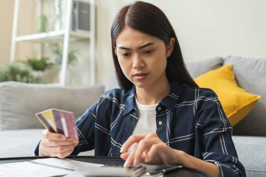 Business financial concept, stressed asian young business woman using calculator for calculate accounting expense of bill, tax for payment on due deadline, trying to find money to pay credit card debt