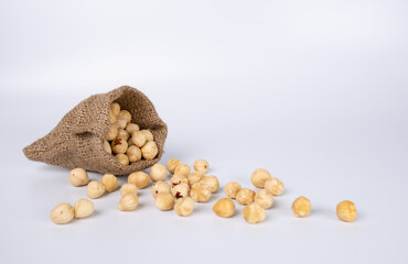 Nuts in The Sack Spilling Over White Background