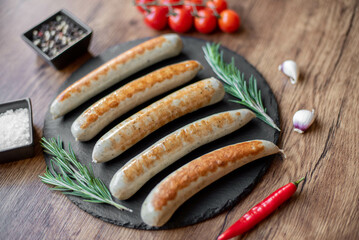 grilled sausages with spices on a rustic background