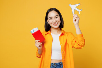 Young woman wear summer casual clothes hold passport ticket airplane mock up isolated on plain...