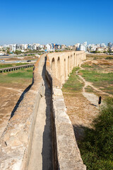 Fototapeta na wymiar Old Kamares Aqueduct or Bekir Pasha Aqueduct near Larnaca, Cyprus. Scenic view of historical landmark and popular tourist attraction, distinctive arches in Roman style, outdoor travel background