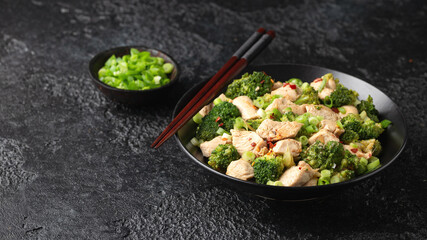 Stir fried Chicken and Broccoli in black bowl