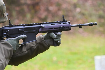 A soldier with a rifle in his hand in the field during the fight.