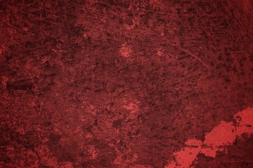 Fototapeta premium A textured background featuring deep red tones with a distressed, grunge appearance. The surface shows scratches and uneven patterns, creating a vintage feel.