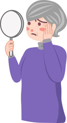 鏡を手に持って顔を見ているシニア女性